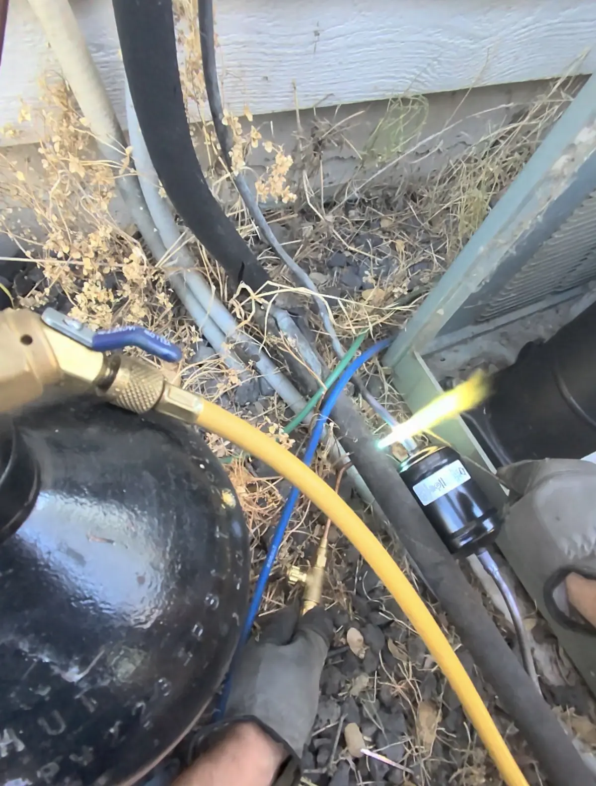 New liquid-line filter drier being brazed during AC compressor replacement in Lincoln, CA