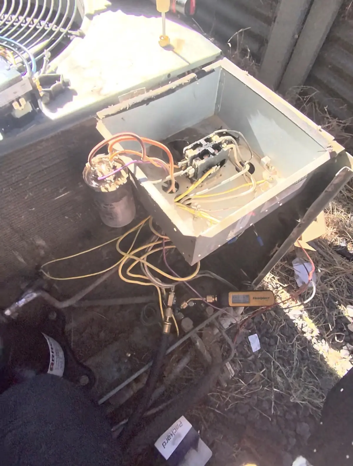 Removing the old capacitor and contactor during AC compressor replacement in Lincoln, CA