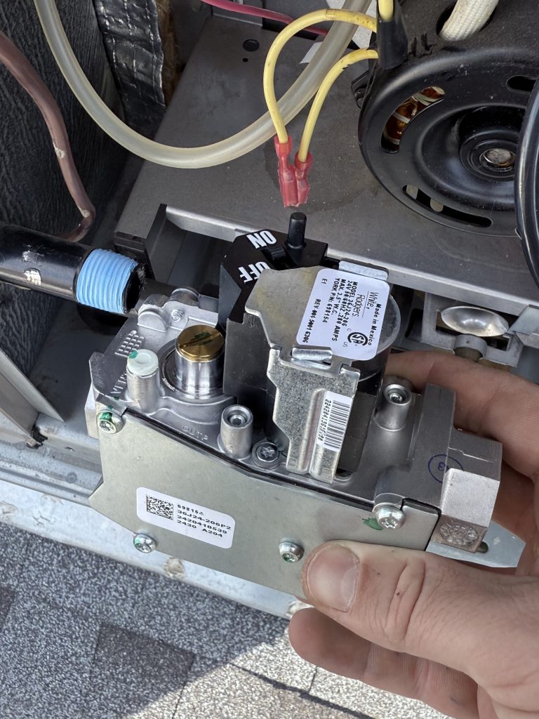 Technician holding a furnace gas valve assembly during the Morgan Creek heating repair