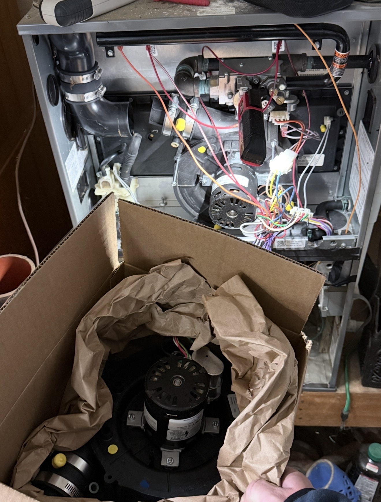 Open high-efficiency furnace and boxed inducer assembly during a Newcastle heating repair