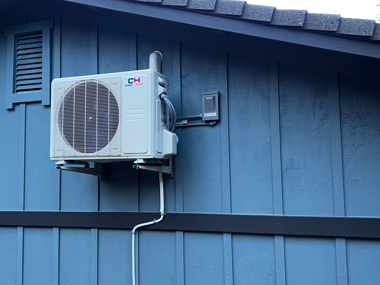 Cooper & Hunter mini-split outdoor unit mounted on wall brackets outside an Auburn garage