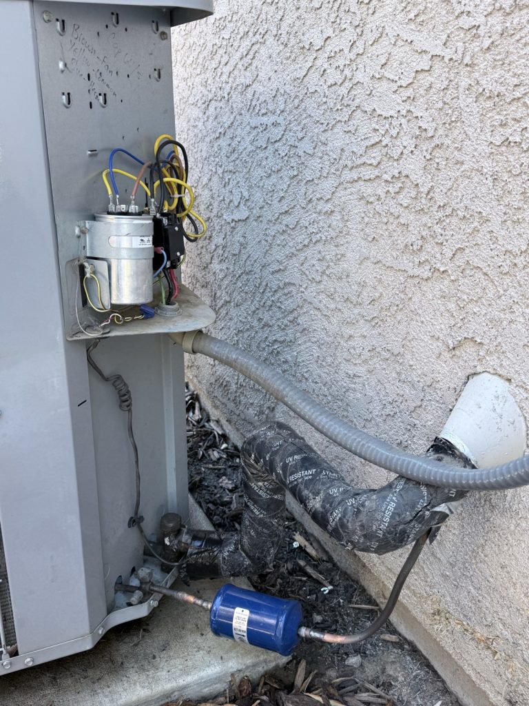 Outdoor AC unit with the service panel open, showing the capacitor and wiring during a Sacramento repair